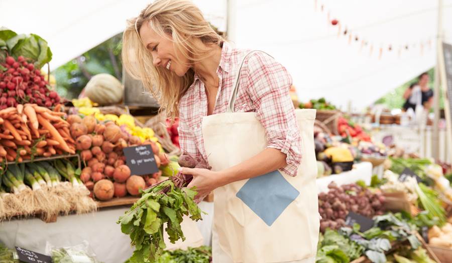 A woman checking out the produce at a local farmer's market