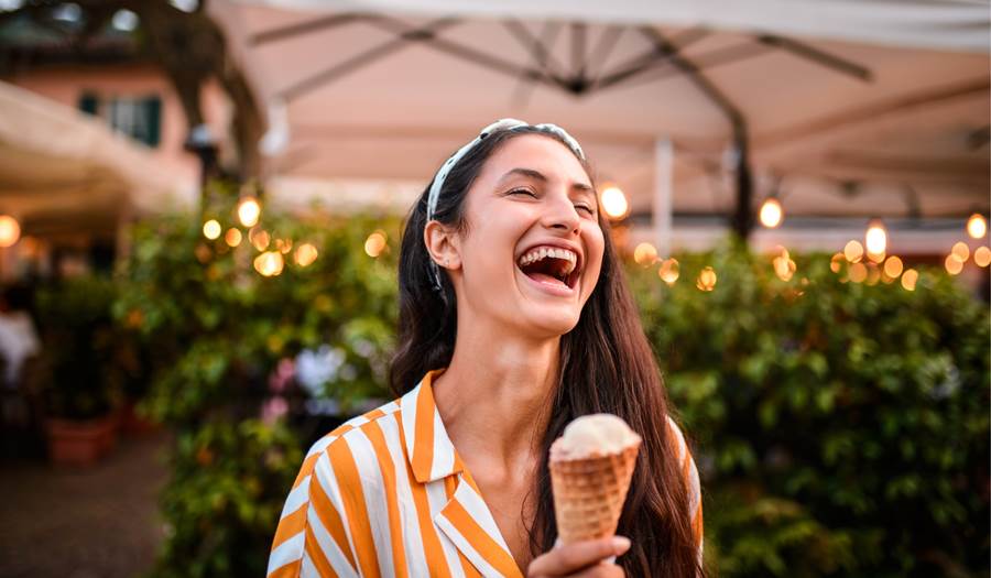 A woman enjoying an ice cream cone in the summer